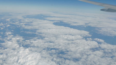 Beautiful view of the blue sky with clouds from the porthole of the plane during the flight. 4kの写真素材