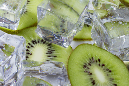 Kiwi fruit slices in a bowl with ice cubes.の写真素材