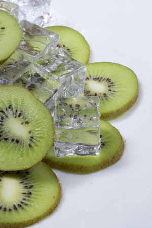 Kiwi fruit slices in a bowl with ice cubes.の写真素材