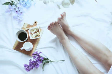 A white one-piece lady relaxing in her bedroom bed on a refreshing morning