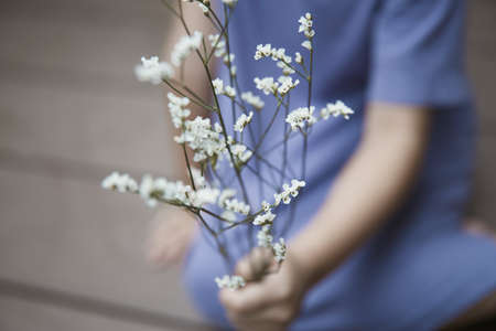 Girl with white flowers in blue-purple clothes