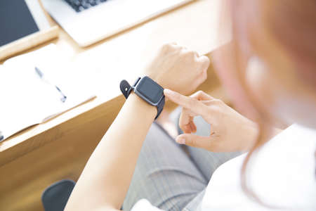A woman watching a smartwatch in her office