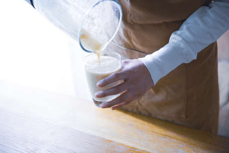 A woman making a fruit smoothie at her coffee shopの写真素材