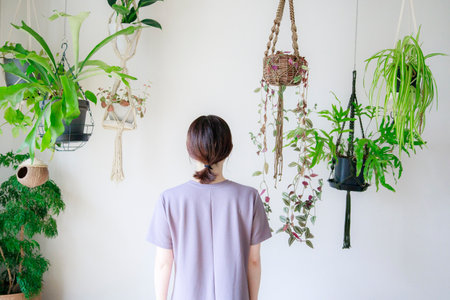 A Japan woman standing in an room with bright plants