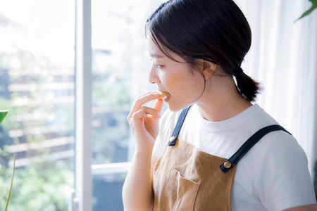 A woman in an apron eating sweets