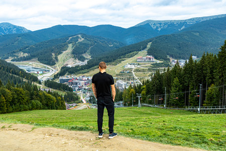 A man stands on a mountain overlooking the townの写真素材