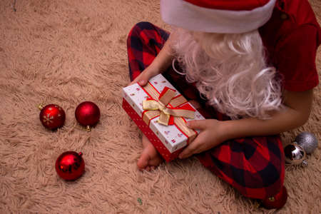 new year. Baby holds gift in his handsの写真素材