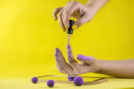 A girls hand holds a nail polish brushの写真素材