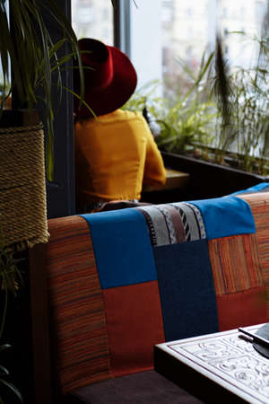 sad girl in a yellow dress and a hat sits in a cafe, pandemic, isolation.