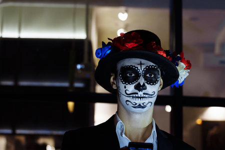 A man wearing skull make-up for. All souls day. Boy sugar skull makeup.painted for halloween. dead in the city. zombie walk.の写真素材