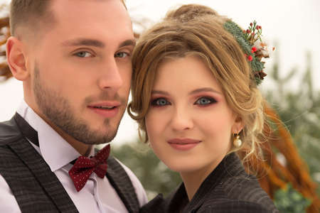 the couple is hugging and close to the kiss, holding hands, a bouquet in their hands. A suit with a...
