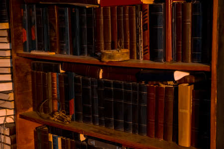 old books stand on wooden shelves, shelving with books. on the shelf is an old, rusty lock and a bunch of keys, the concept of science, the door to education, trainingの写真素材