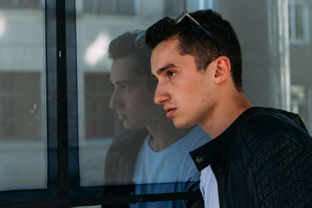 Attractive, sexy guy standing on the street in sunglasses. self-confidence, flatulence and...