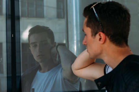 Attractive, sexy guy standing on the street in sunglasses. self-confidence, flatulence and...