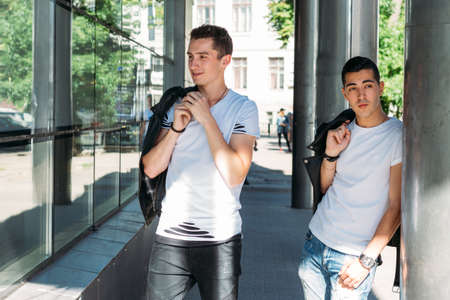 beautiful and attractive guy is standing in the city, posing. walk around the city in black glasses. communication. meeting friends.の写真素材