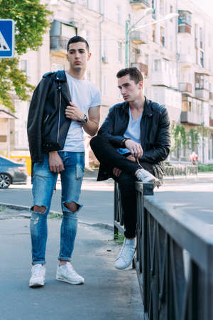 beautiful and attractive guy is standing in the city, posing. walk around the city in black glasses. communication. meeting friends.の写真素材