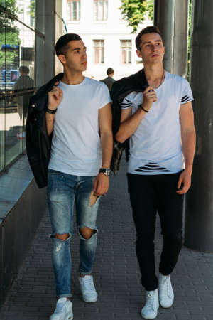 beautiful and attractive guy is standing in the city, posing. walk around the city in black glasses. communication. meeting friends.の写真素材