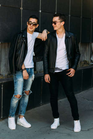 beautiful and attractive guy is standing in the city, posing. walk around the city in black glasses. communication. meeting friends.の写真素材