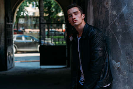 Attractive, sexy guy standing on the street in sunglasses. self-confidence, flatulence and arrogance.model, posing, portrait of a young manの写真素材