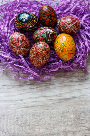 seven painted Easter eggs lie on a violet backgroundの写真素材