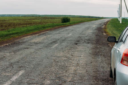 the car is on the road, the side of the car in the field on the road. Green field. countryside. rent.to rent a carの写真素材