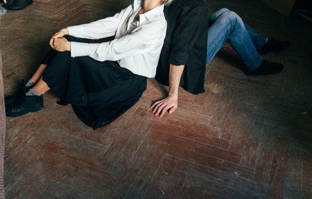 the couple is sitting on the wooden floor, back to back. deployed in different directions. outlook on lifeの写真素材