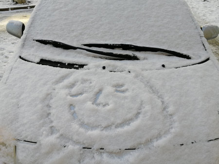 Snow happy face on the car window. Smile in the snow, happy cheerful image. winterの写真素材