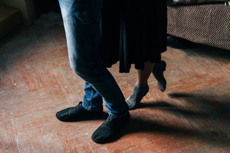 the girl approached behind to the man. photo legs. the couple is standing on the floorの写真素材