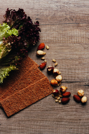 nuts, crackers, calad lie on a wooden table, the concept of proper nutritionの写真素材