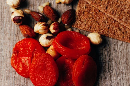 hazelnut, bread, dry apricot lie on a wooden table, the concept of proper nutritionの写真素材
