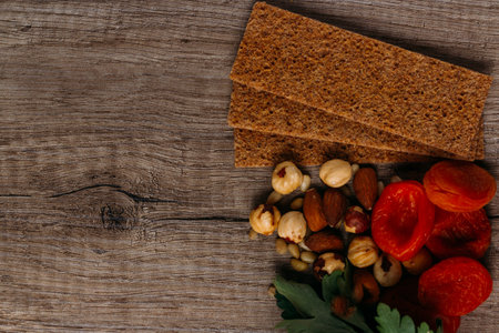 hazelnut, bread, dry apricot lie on a wooden table, the concept of proper nutrition
