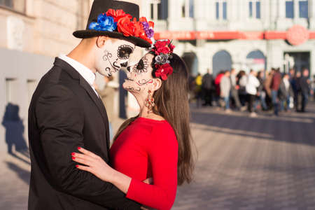 A couple, wearing skull make-up for. All souls day. Boy and girl sugar skull makeup.painted for...