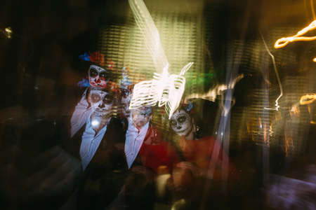 Blur. A man and a woman with a visage, a pattern of skulls, a zombie on the face. Dead at night. A...