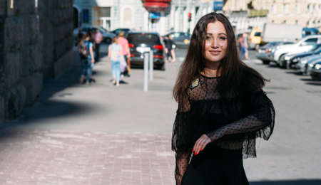 beautiful brunette whirls on a street in the middle of the city, laughs, smiles, happiness, funの写真素材