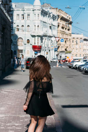 beautiful brunette whirls on a street in the middle of the city, laughs, smiles, happiness, funの写真素材