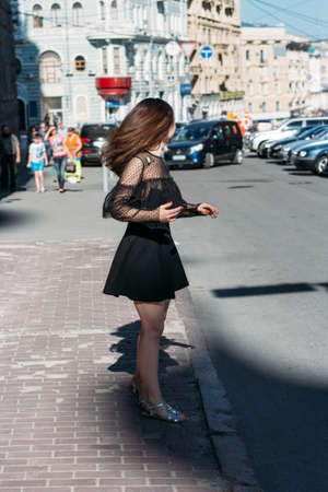 beautiful brunette whirls on a street in the middle of the city, laughs, smiles, happiness, funの写真素材