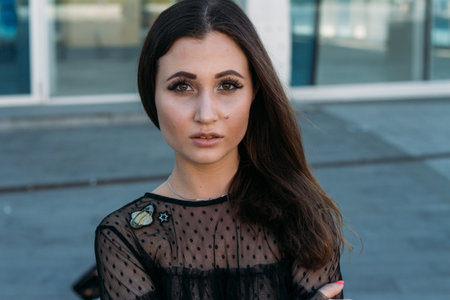 Emotional portrait of Fashion stylish portrait of pretty young woman. city portrait. sad girl. brunette in a black dress with stars and planets on a dress. expectation. dreamsの写真素材