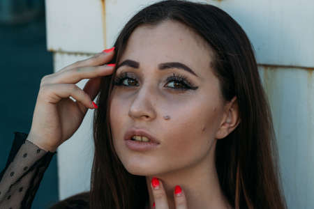 Emotional portrait of Fashion stylish portrait of pretty young woman. city portrait. sad girl. brunette in a black dress with stars and planets on a dress. expectation. dreamsの写真素材