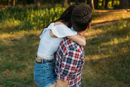 the girl jumped on the guy's back.he holds her legs.check shirt and jeans.の写真素材
