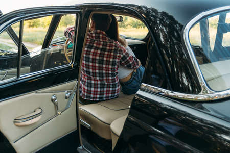 couple, man and woman are sitting in the car, the guy is hugging the girl. traveling together. check shirt and white blouse, darkiesの写真素材