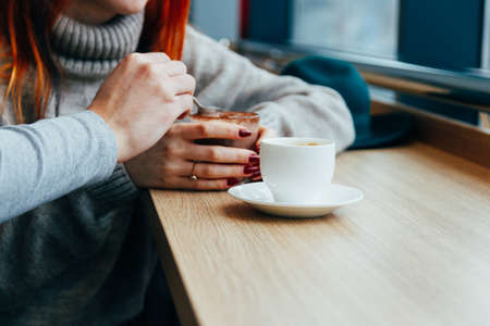 meeting at a cafe, red-haired girl drinking hot chocolatecommunication.の写真素材