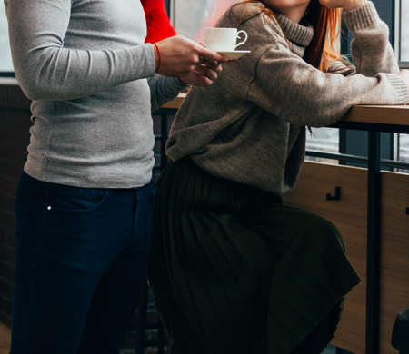 the man brought coffee, tea to the girl who sits at the table. waiter. the guy who cares for a friend. couple in love. spending time together. a cafe. recreation. communication.の写真素材