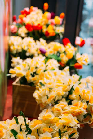 bouquets of yellow daffodils and red tulips stand in flower beds on a glass showcase. buy a gift,の写真素材