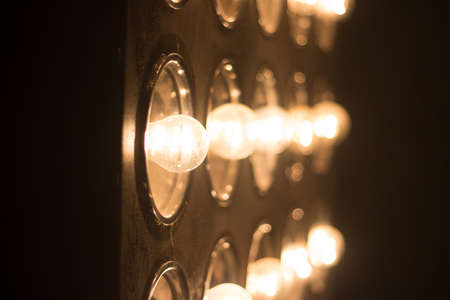 many blur Light bulbs background over dark wall. shine. scene. soffits