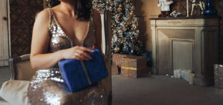 girl in a shiny dress near the Christmas tree with a gift, Christmas, New Year Christmas tree...