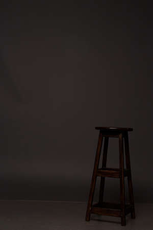 brown chair stands on a gray background, studio, concept of waitingの写真素材