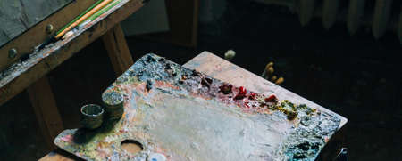 The palette with oil paints lies next to the canvas. room artist. artist's workshop. hobby.の写真素材