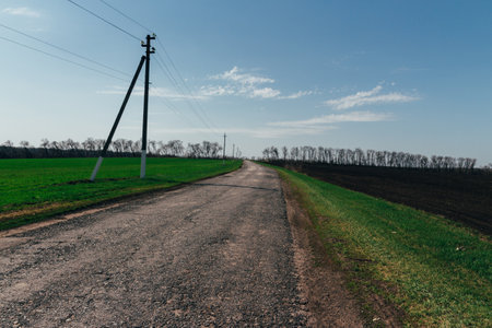 plowed field on which agricultural machinery rides. Summer day two tractors to plow, plow the soil on sloping, cornfield. Agricultural land treatment before planting.の写真素材