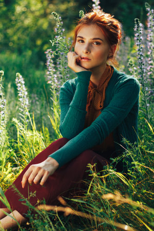 portrait of a beautiful girl with brown hair among the flowers in the field. summer holiday with flowers.の写真素材