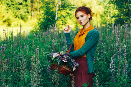 portrait of a beautiful girl with brown hair among the flowers in the field. summer holiday with flowers.の写真素材